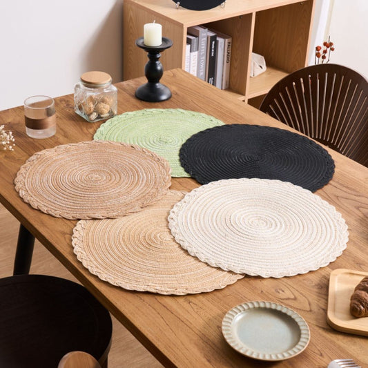 Set of round placemats in various colors on a wooden table.