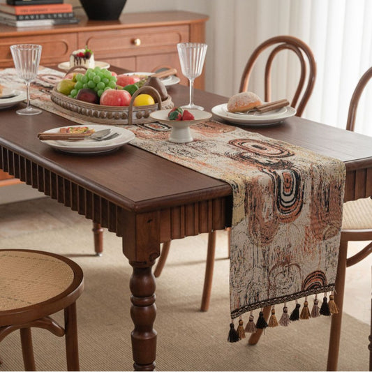 Dining table set with a decorative table runner, plates, and glasses in a home setting.
